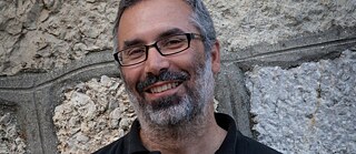 Verleger Roberto Keller vor einer Wand